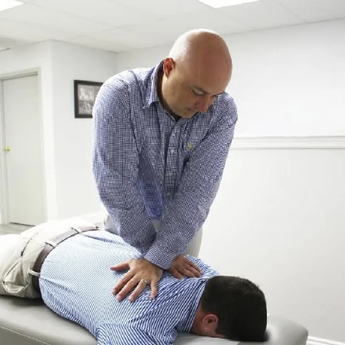 Dr. Jon Pinkston adjusting a patient on table